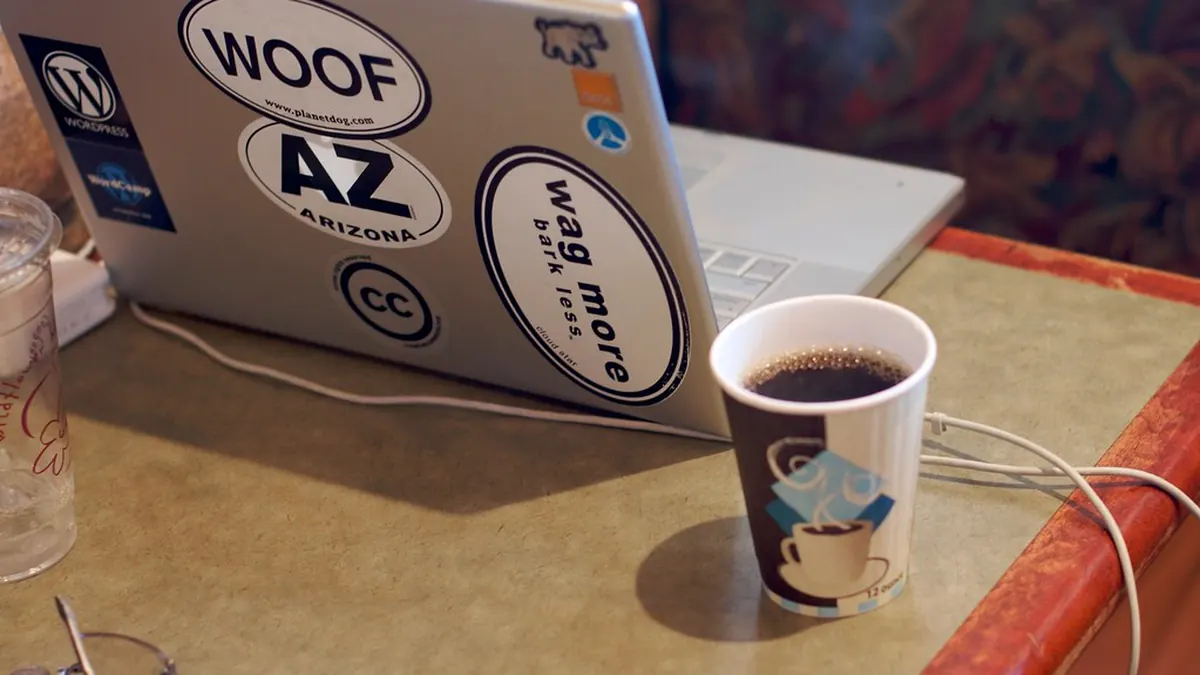 Laptop dan cangkir kopi di meja kerja untuk meneliti informasi