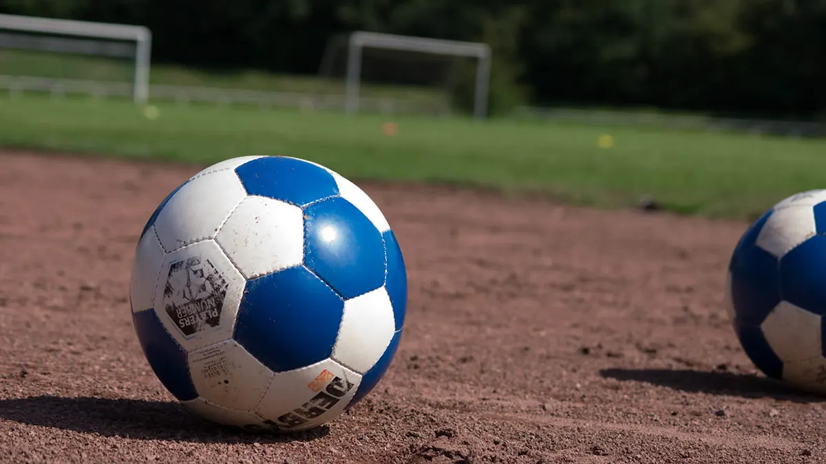 Bola sepak di atas rerumputan lapangan